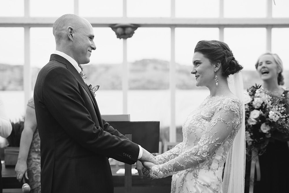 Elegant wedding ceremony in a bright indoor venue with large windows.