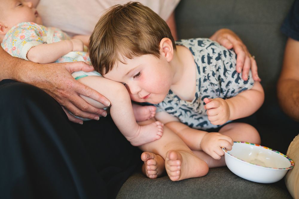 Candid moment of a baby in striped clothing being embraced.