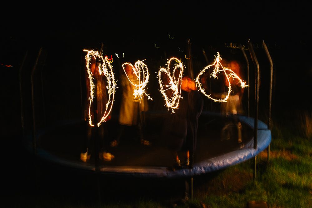 Long exposure night scene showing light trails creating glowing patterns in darkness.