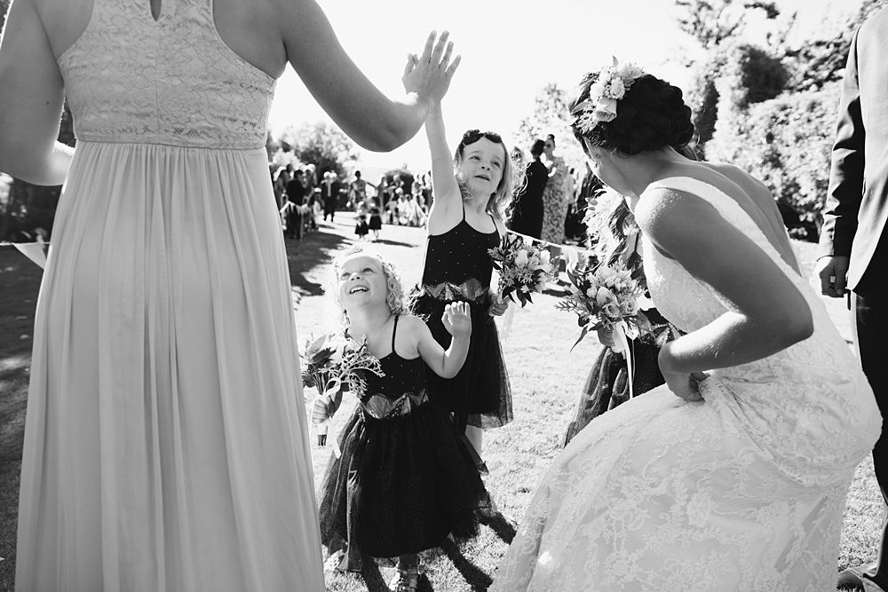 Wedding party members in light blue dresses celebrate outdoors during festivities.