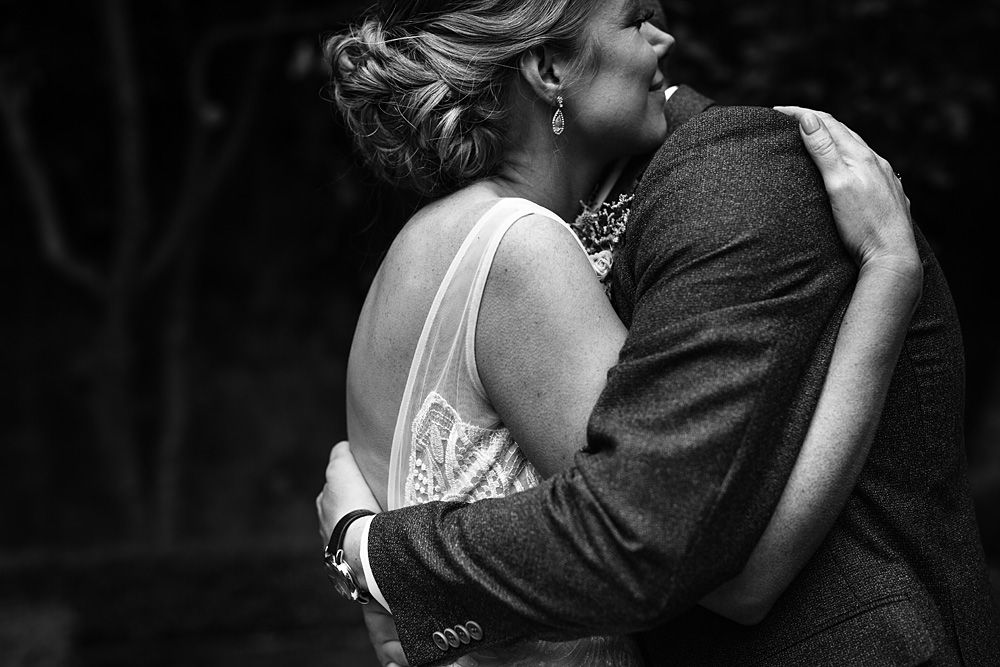 Black and white intimate wedding photograph showing a couple embracing in a tender moment during their dance.