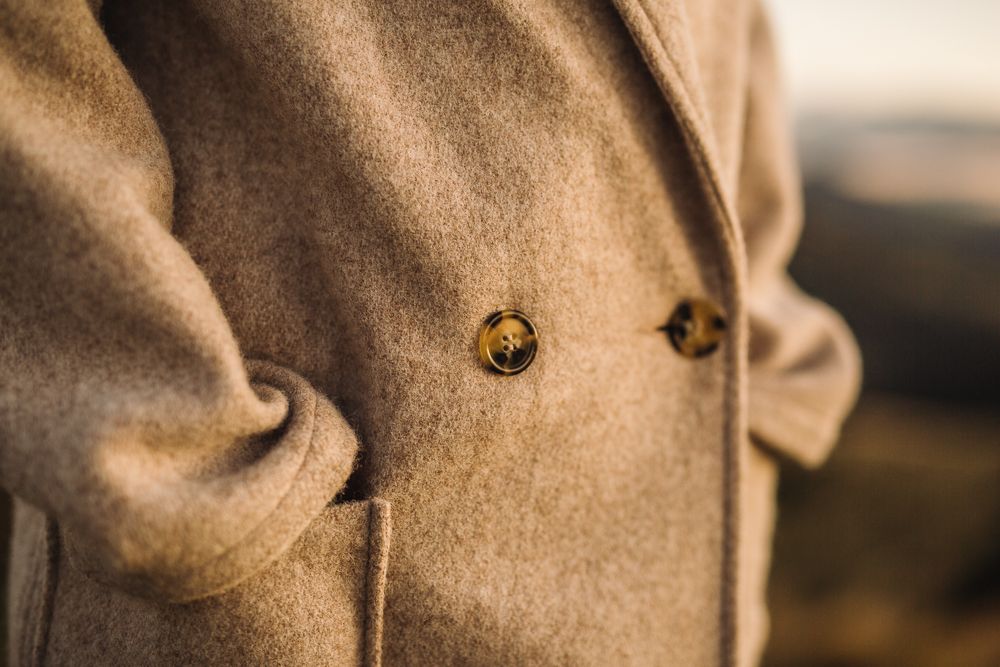 Close-up detail of brown coat buttons in natural lighting.