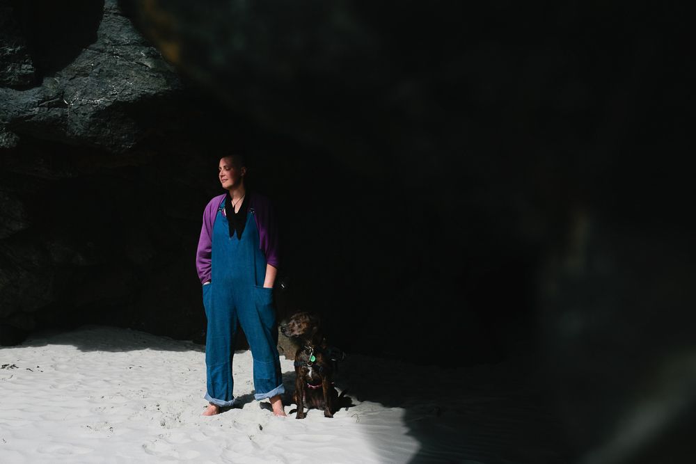 Figure in bright blue outfit standing in dramatic contrast of light and shadow.