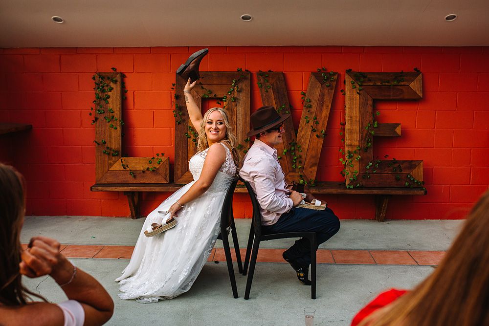 Artistic wedding photo shoot against vibrant red walls with modern industrial decor.
