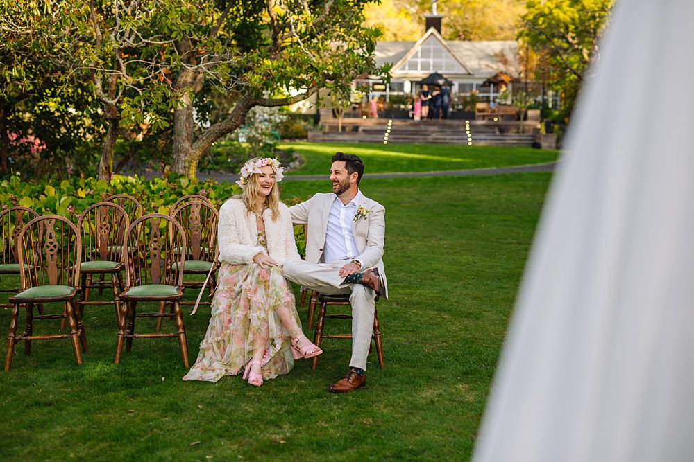 Wedding party celebrates outdoors on a beautiful sunny day with elegant decor and floral arrangements.