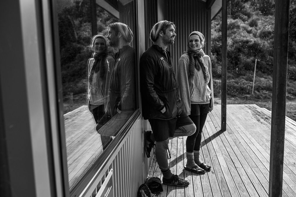 People gathered on wooden deck surrounded by forest in black and white.