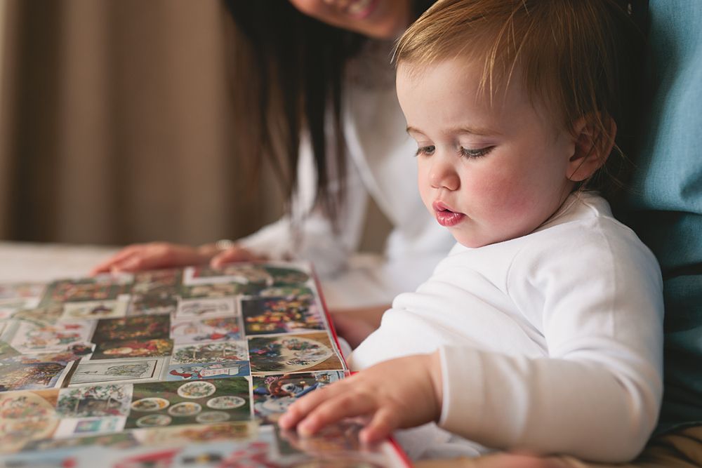 Young child focused intently while looking at picture books.