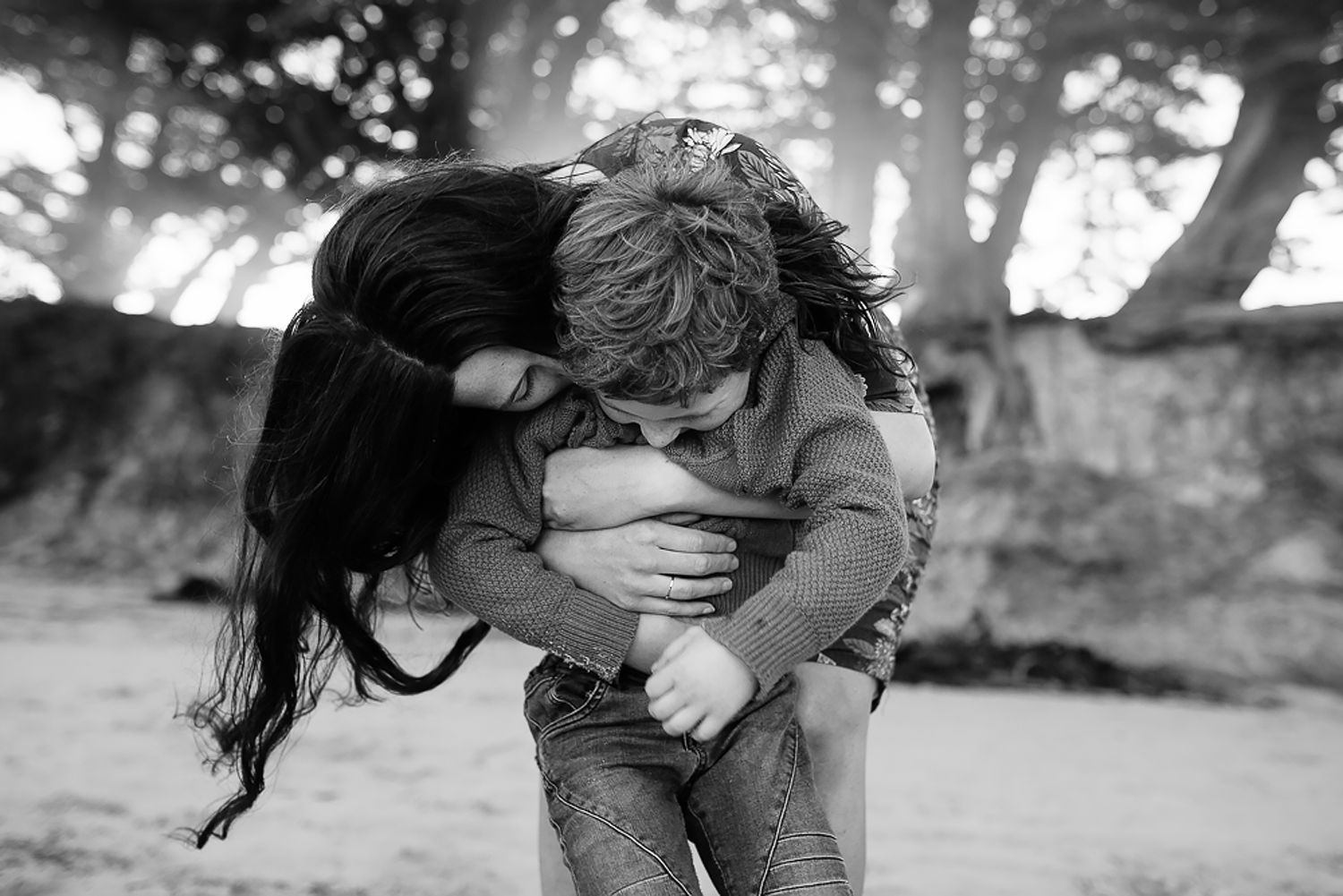 A candid black and white photo showing an intimate embrace outdoors.
