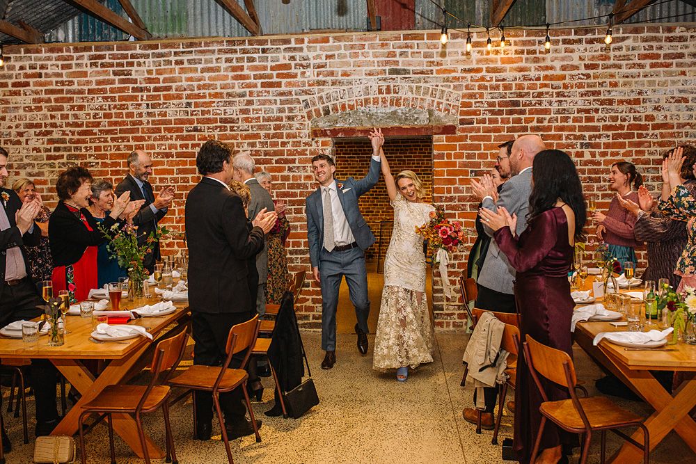 Wedding reception venue with exposed brick walls and wooden furniture.