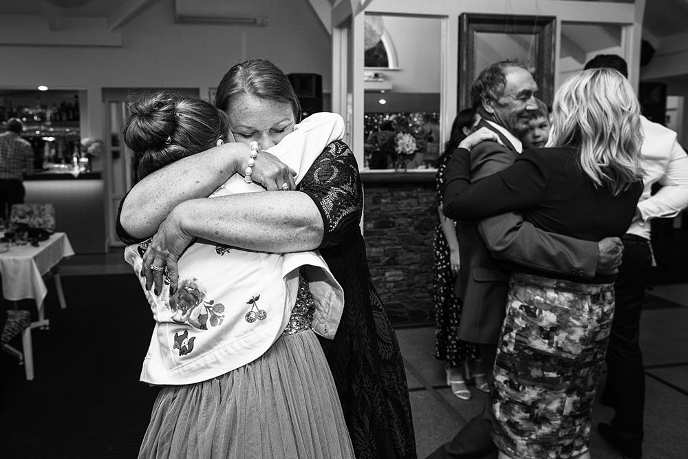 Black and white photos of guests dancing and celebrating at a wedding reception.