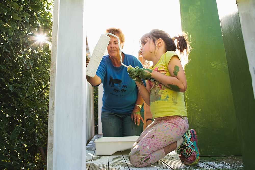 Family enjoys playful moment together in sunlit outdoor setting.