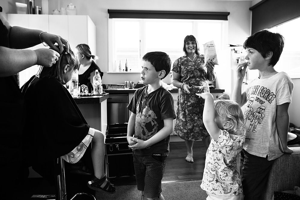 Wedding party members interact in a bright indoor setting with casual atmosphere.