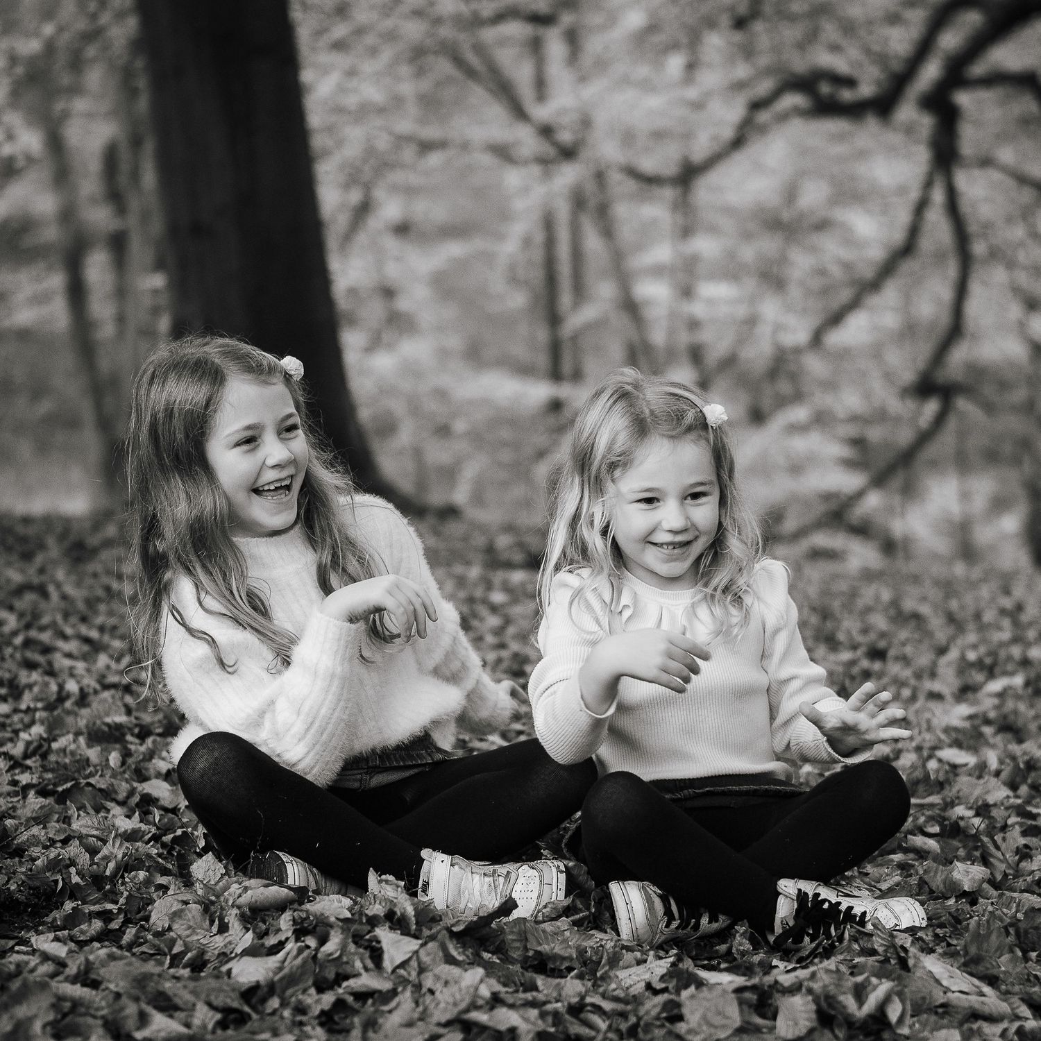 Relaxed  photo day of two  early years sisters laughing naturally.