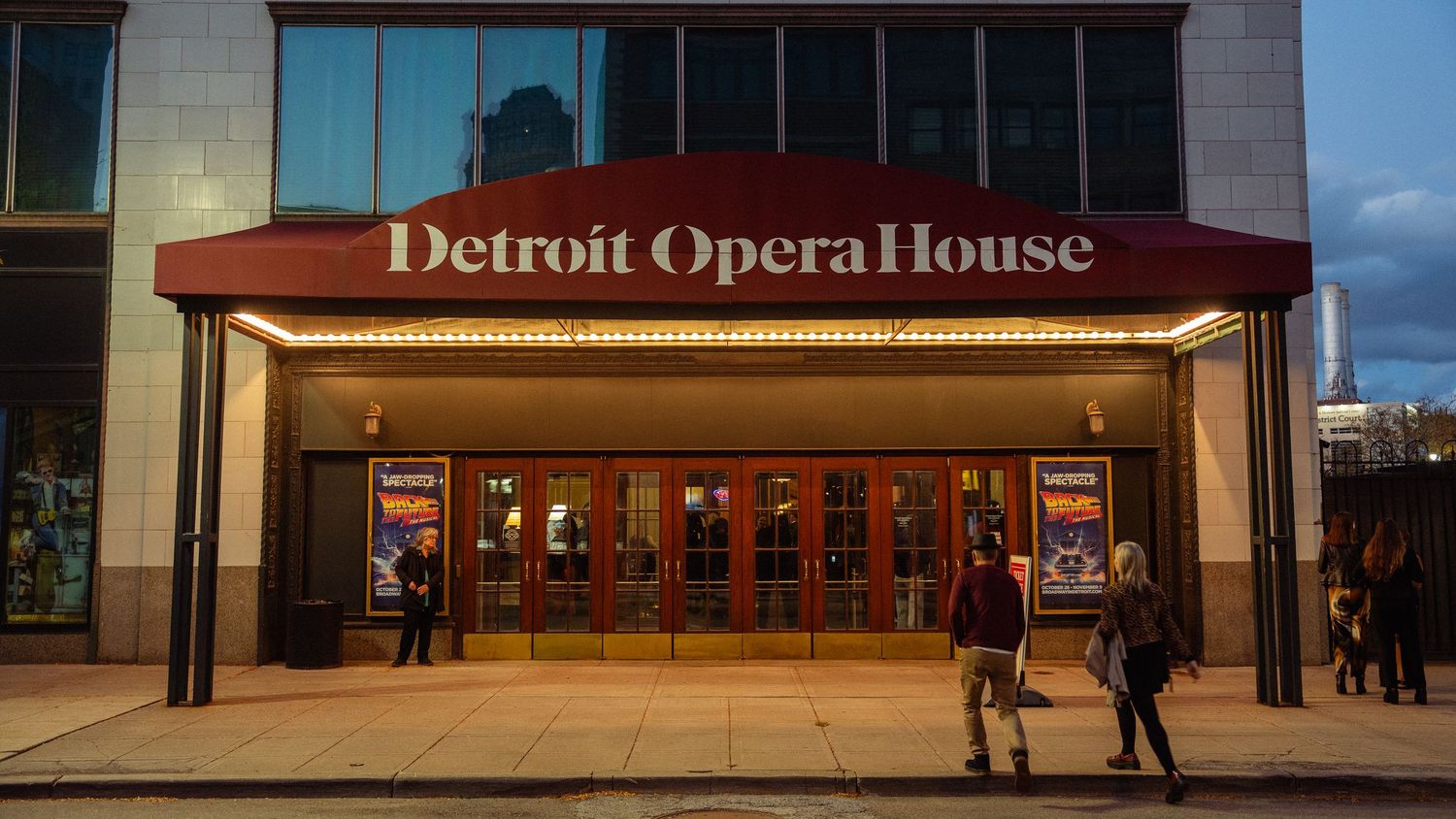 Exterior view of the Detroit Opera House at dusk with illuminated marquee and patrons entering.