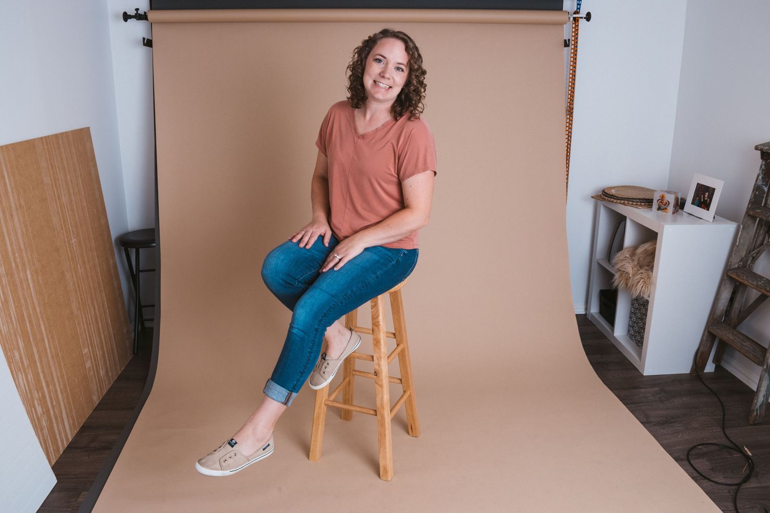 Relaxed, inviting headshot of photographer taken in a home studio, showcasing a warm and approachable professional style