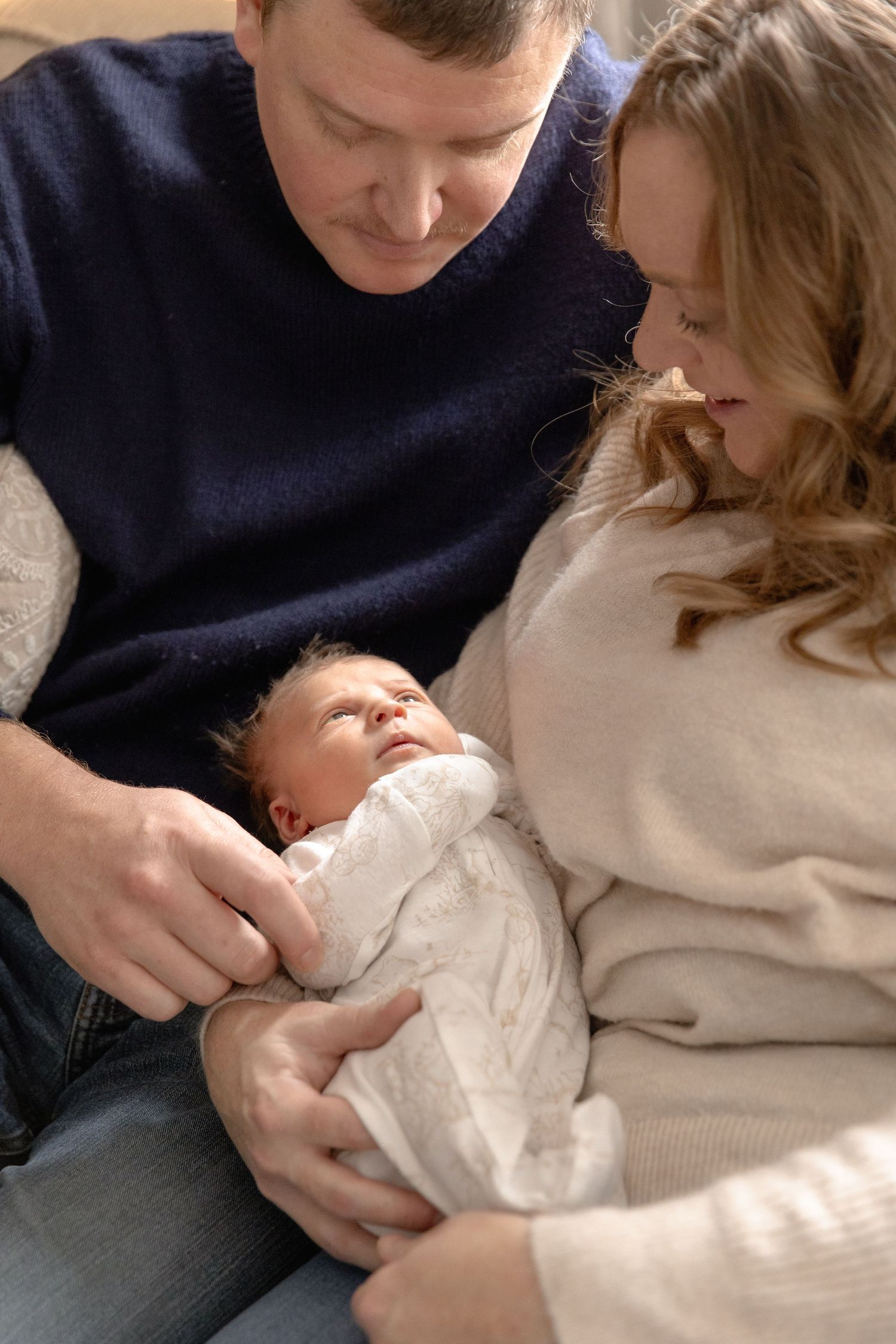 A series of tender moments showing parents cradling and bonding with their newborn baby.