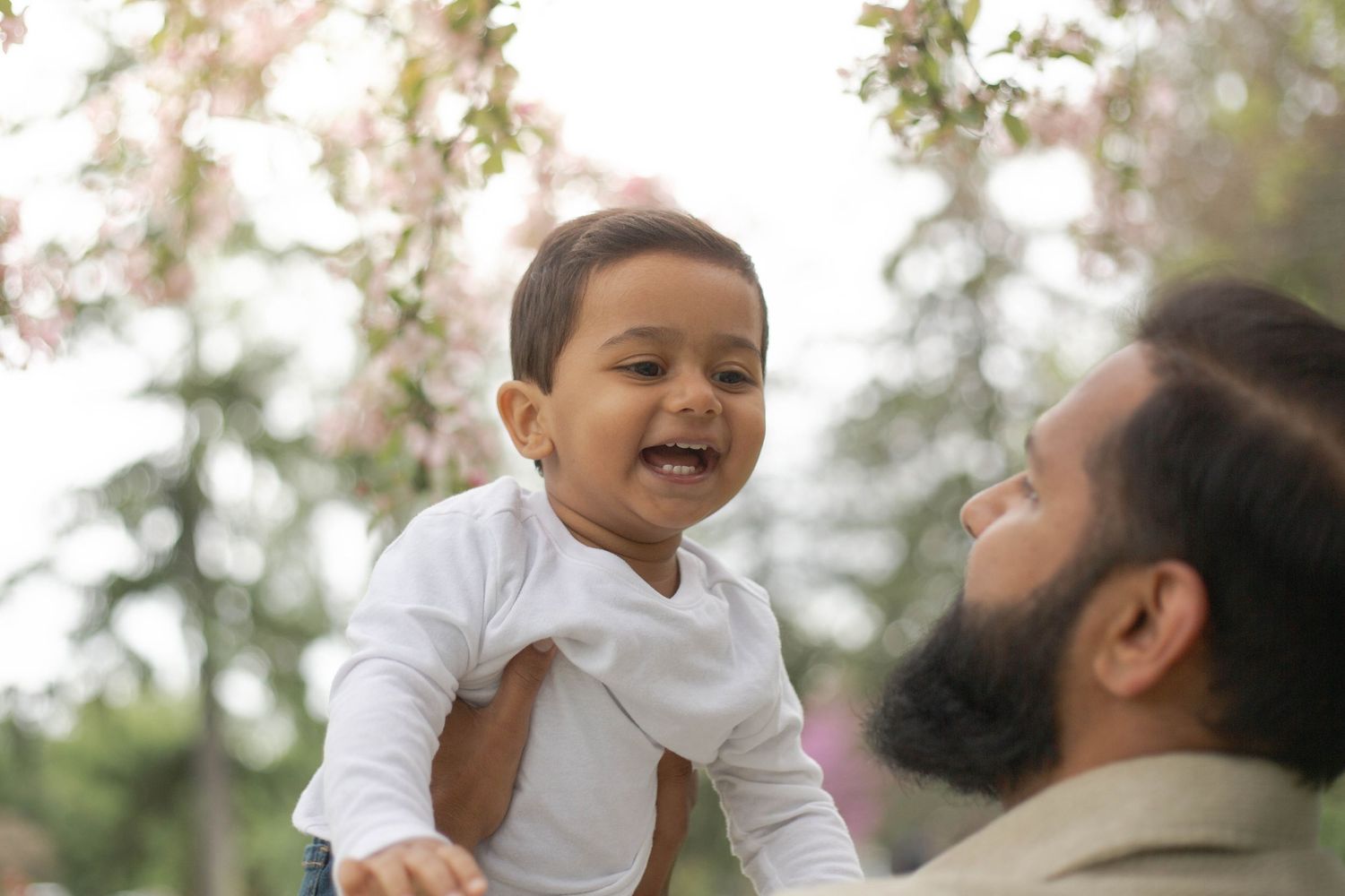 A joyful family moment captured outdoors with natural lighting and expressions of happiness.