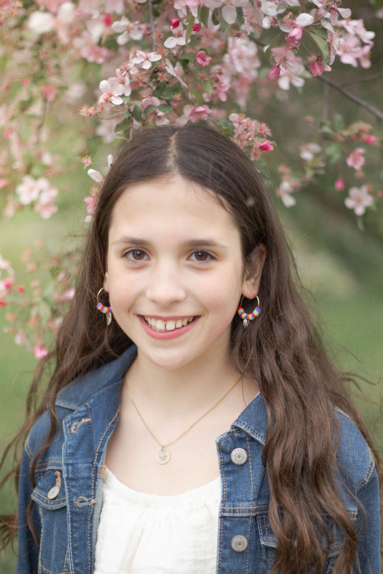 A springtime portrait series with pink cherry blossoms framing someone wearing a denim jacket against a soft blurred background.