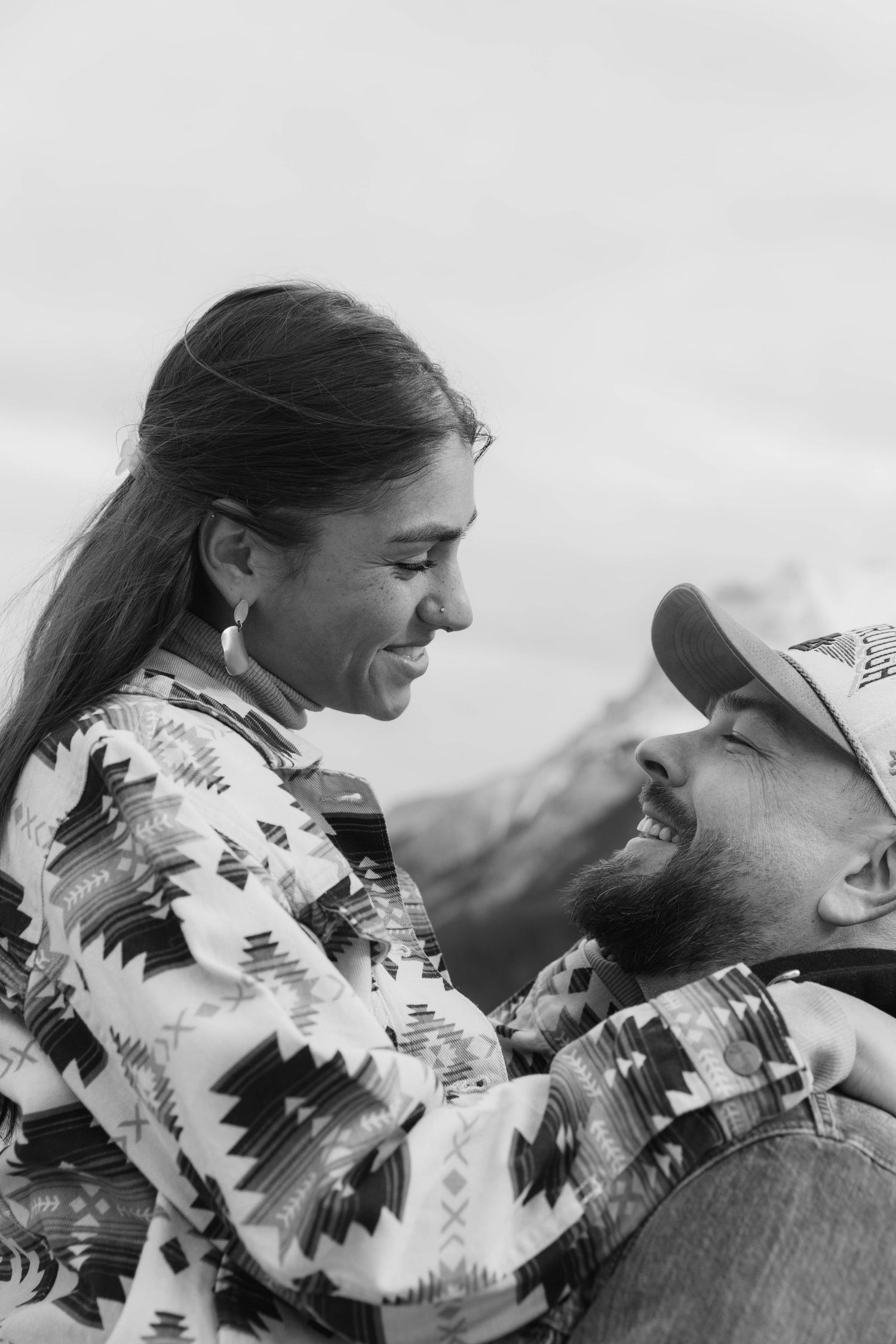 A black and white photo sequence showing a couple embracing and smiling while wearing traditional Native American blankets.