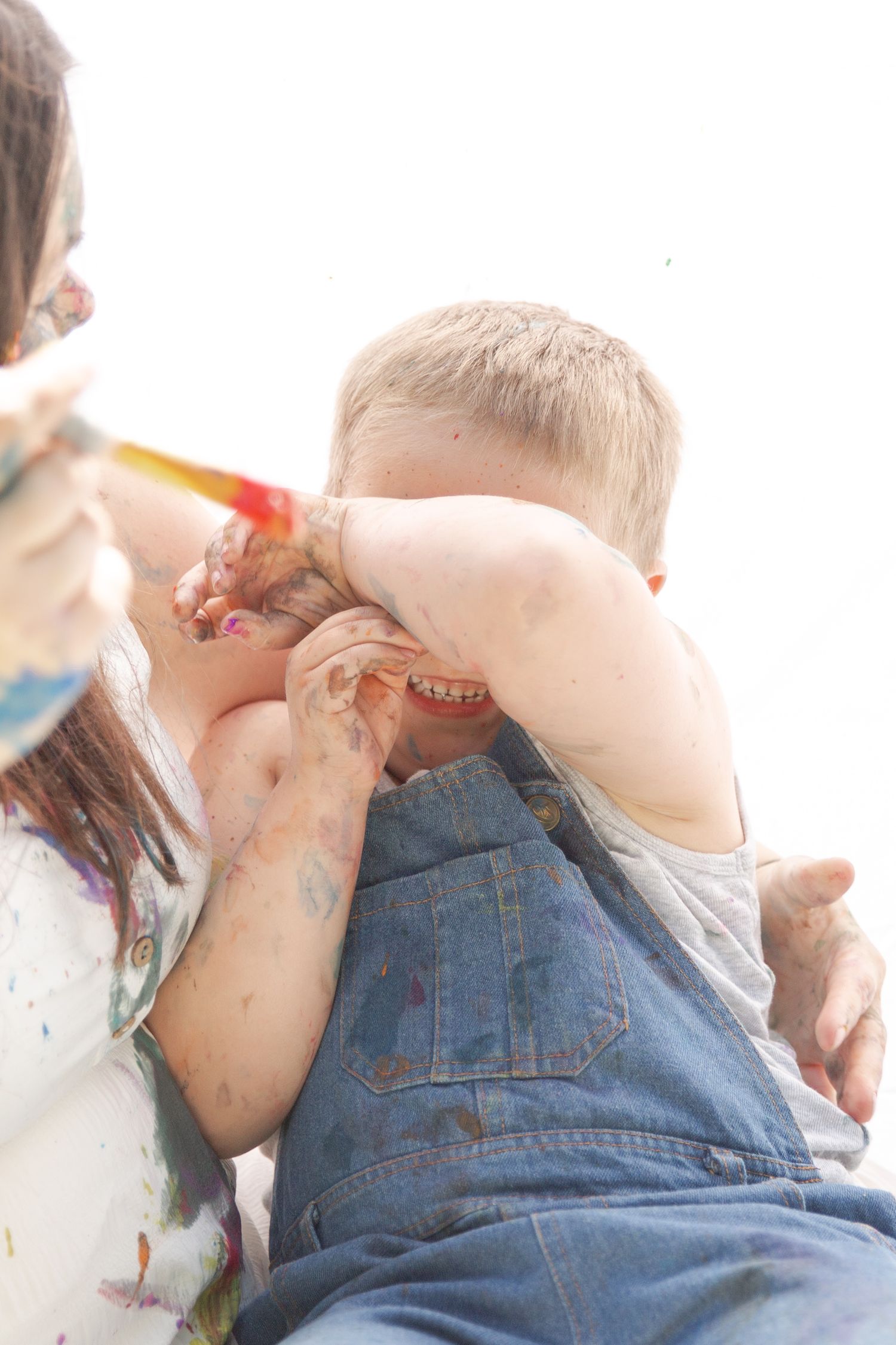 A series of four photos showing a baby in denim overalls crawling and playing against a white background.