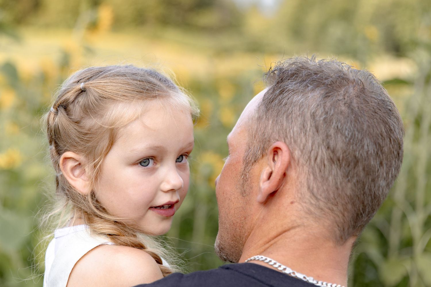A series of candid moments captured between a young child and an older adult in an outdoor garden setting.