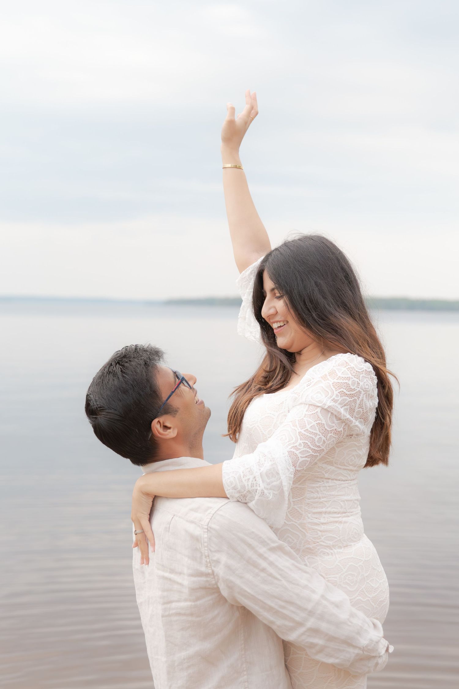 A couple in white outfits share a romantic moment by the water in a multi-panel photo sequence.