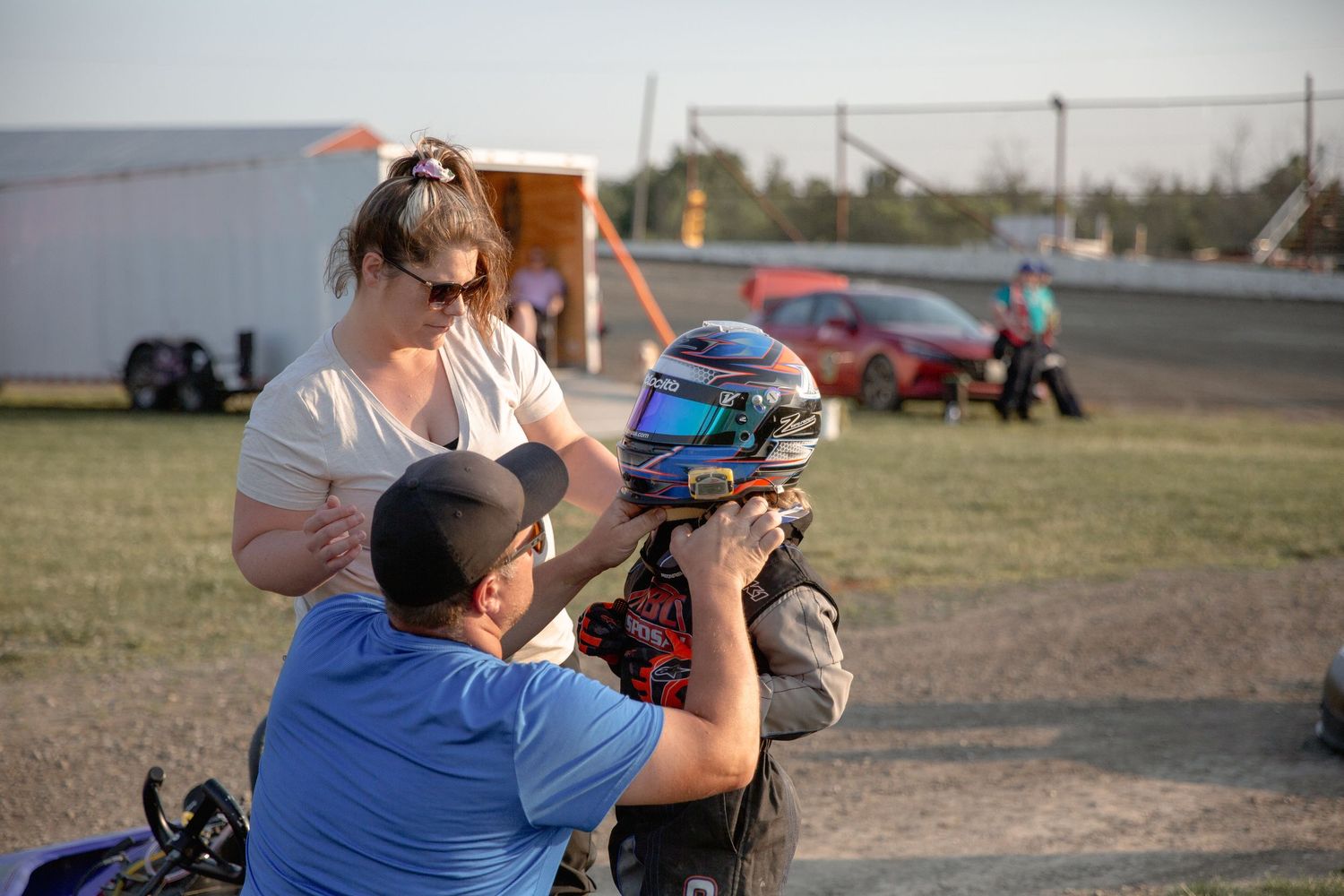 Several people observe a solar eclipse using protective eyewear and viewing equipment in an open field.