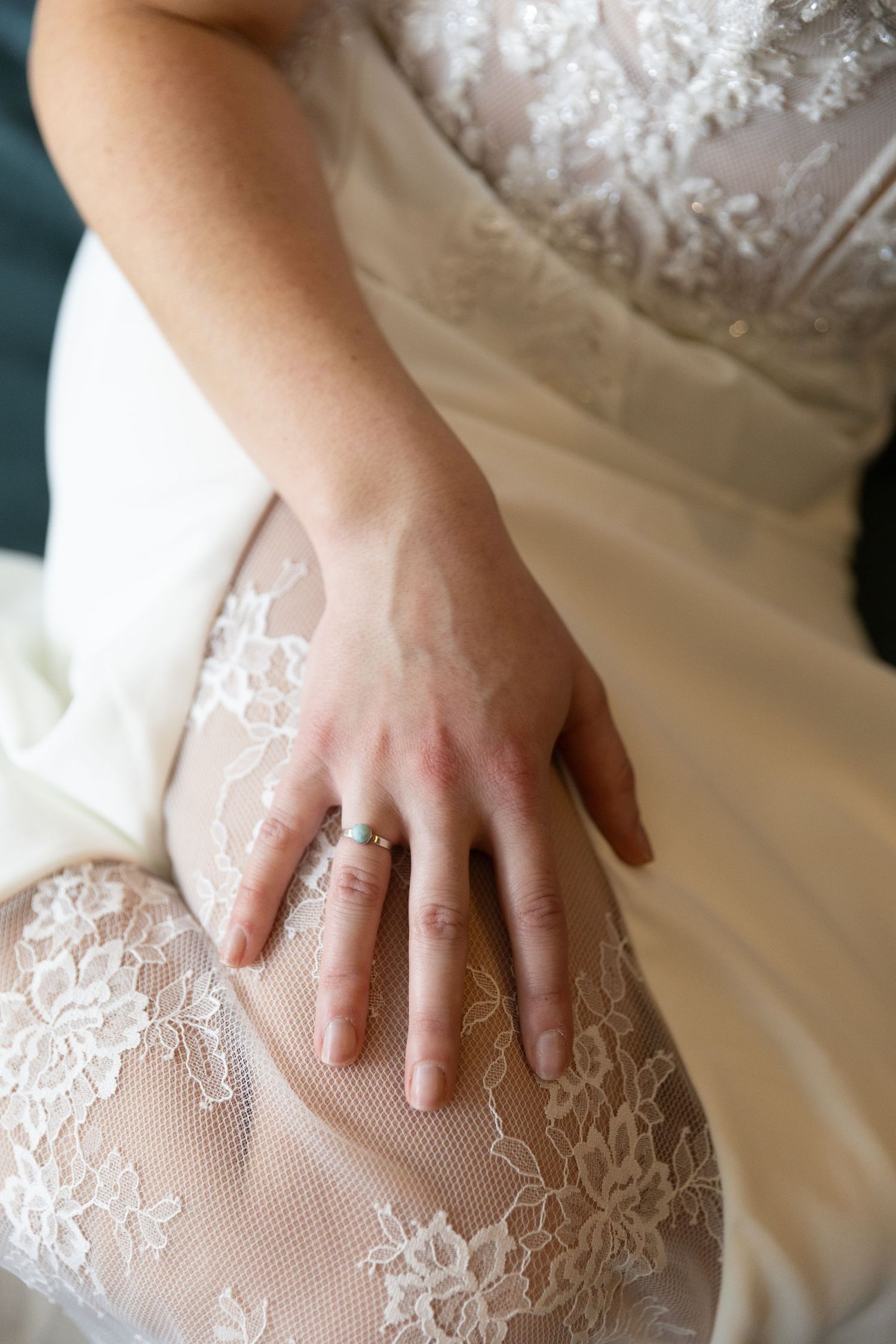 Close-up details of delicate white lace and beading on a wedding dress bodice.