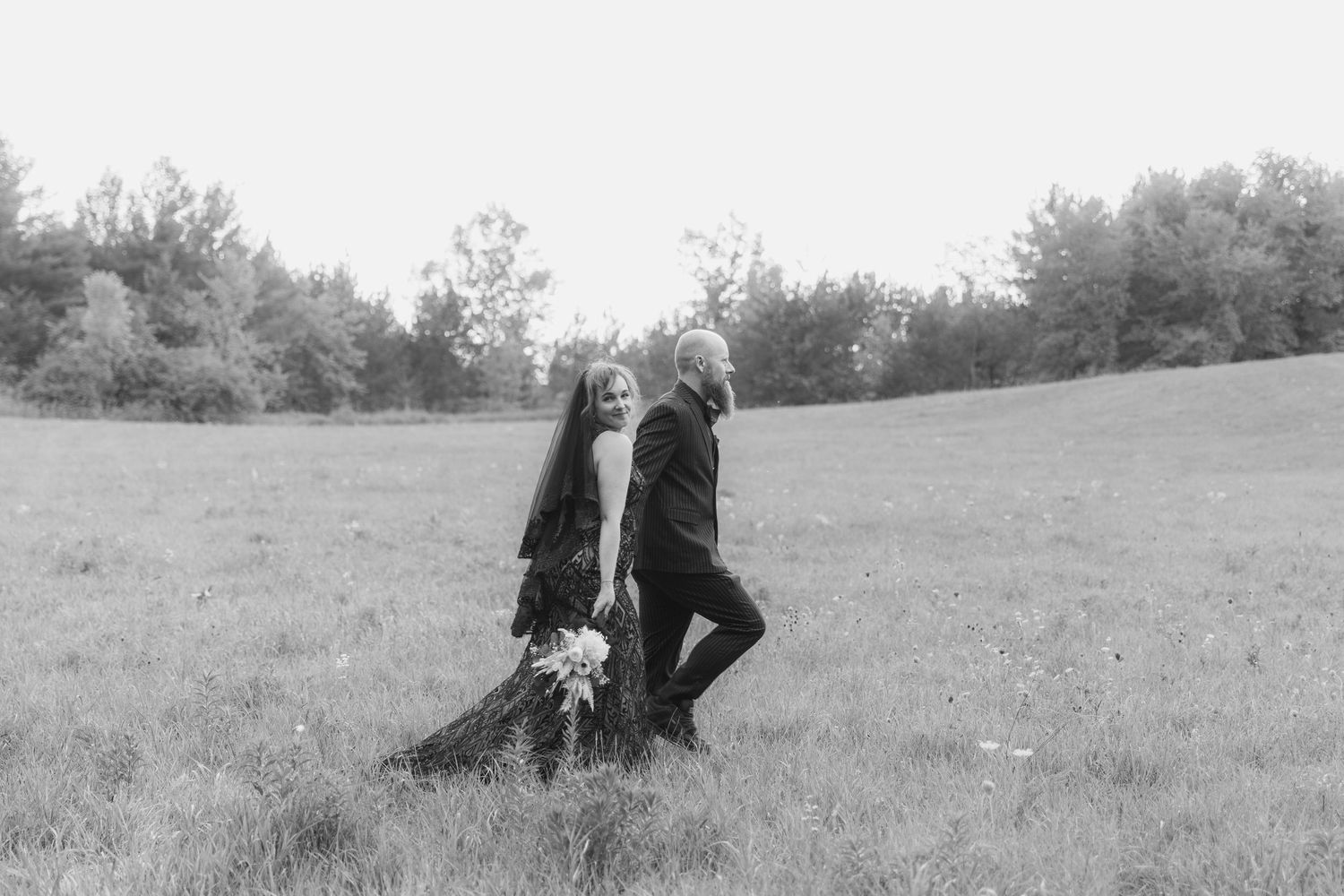 A sequence of black and white photos showing someone walking across a grassy hillside landscape.