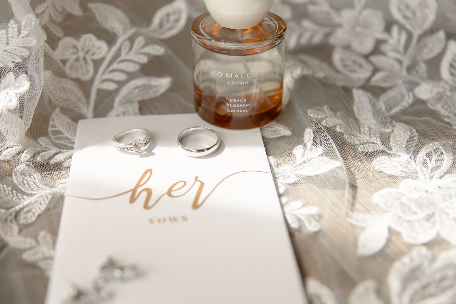 A collection of glass jars with metallic lids arranged among delicate white floral decorations and leaves.