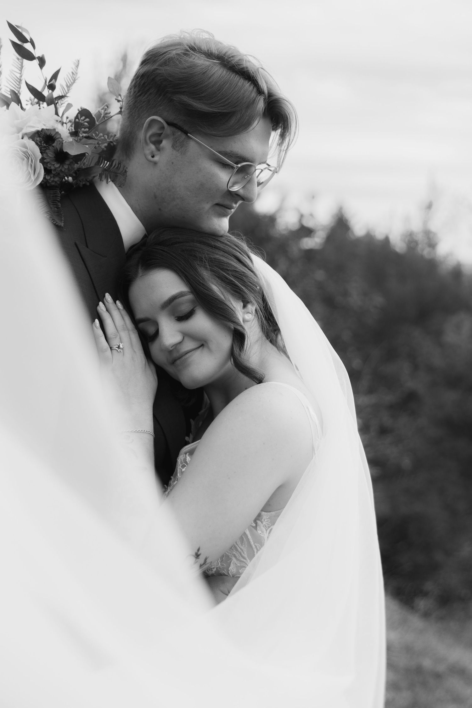 A romantic black and white wedding photo series showing tender moments between a couple in their bridal attire.