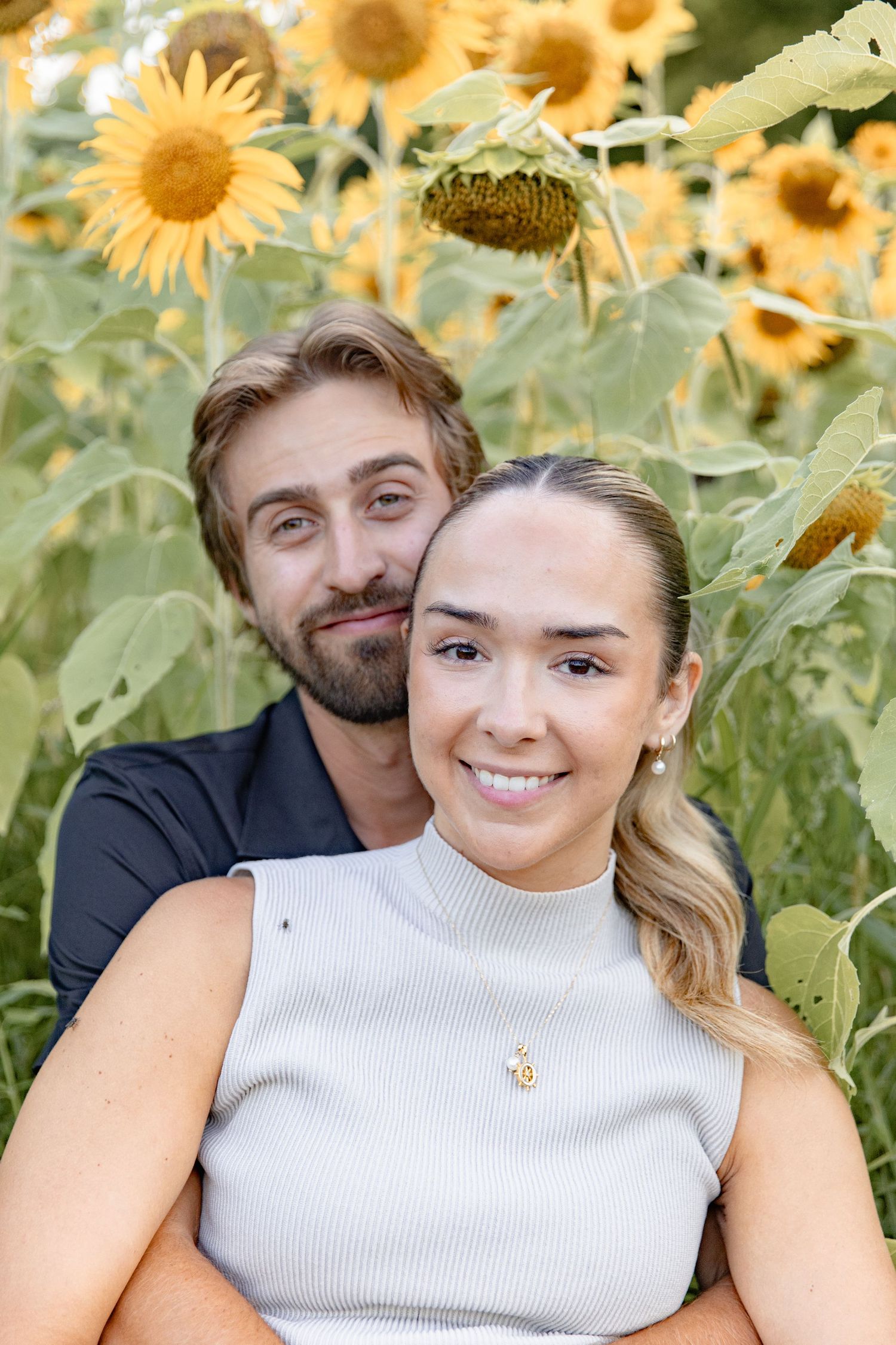 Close-up portraits of a couple sharing tender moments among bright blooming sunflowers.