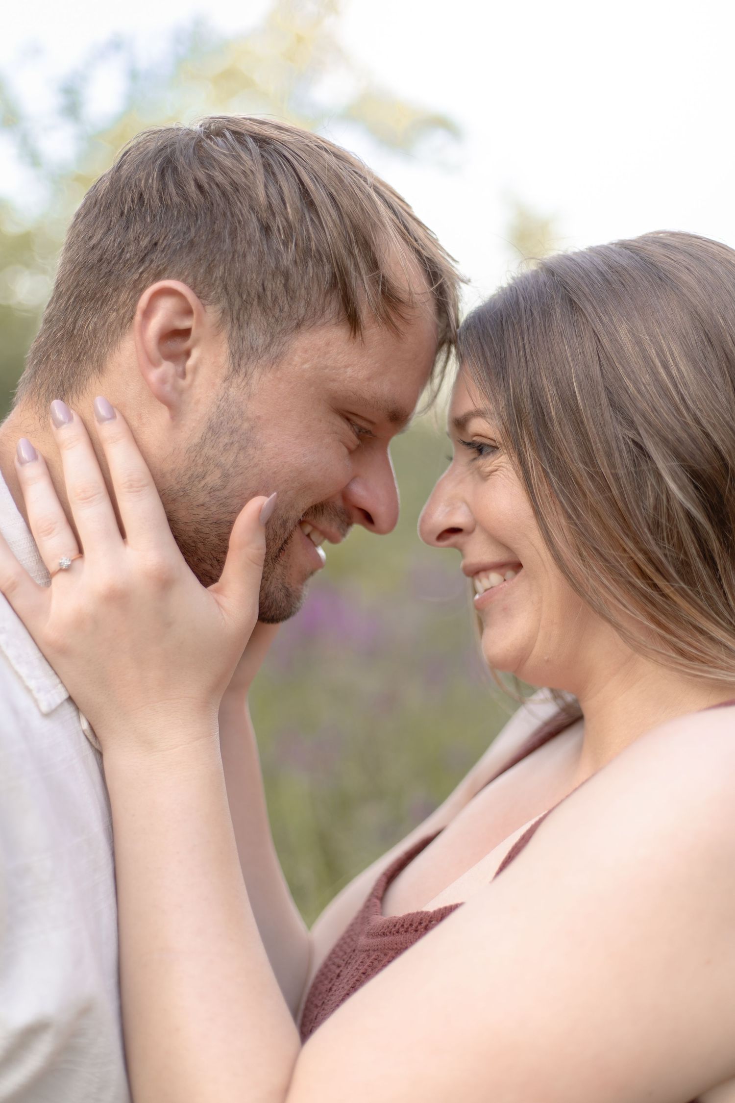 A romantic couple shares tender moments in a series of intimate outdoor portraits with soft natural lighting.