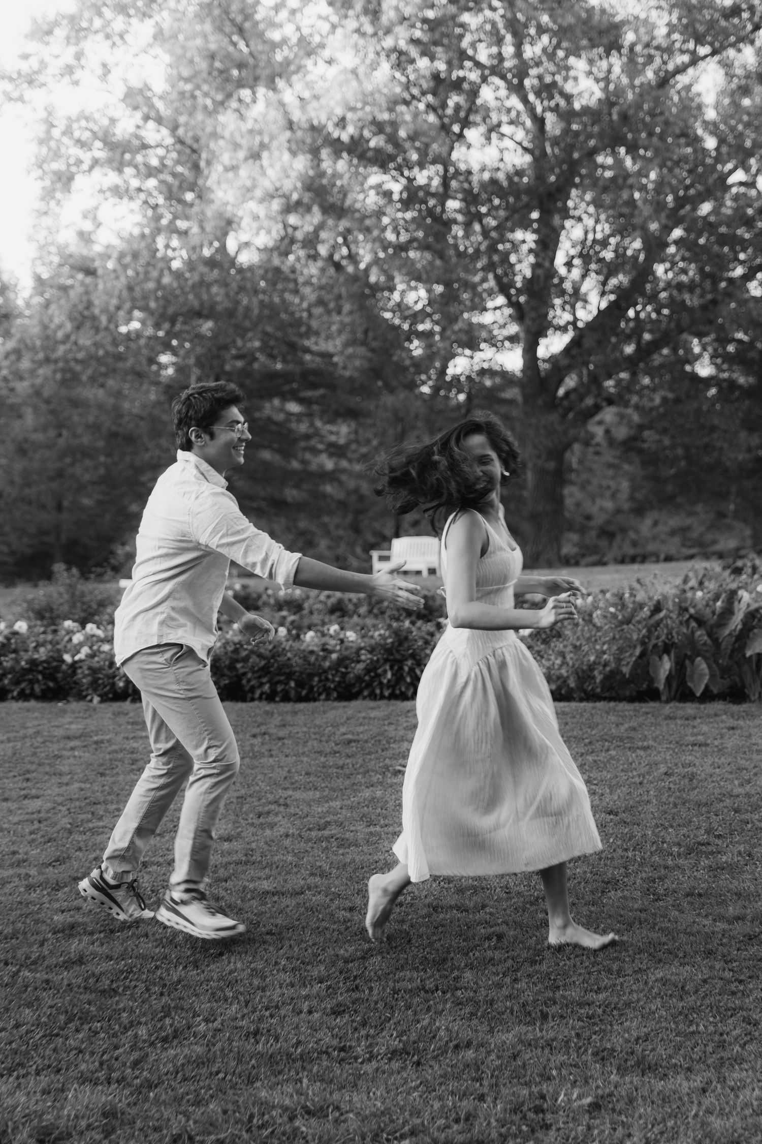 A sequence of black and white photos shows two people playfully chasing each other across a grassy lawn.
