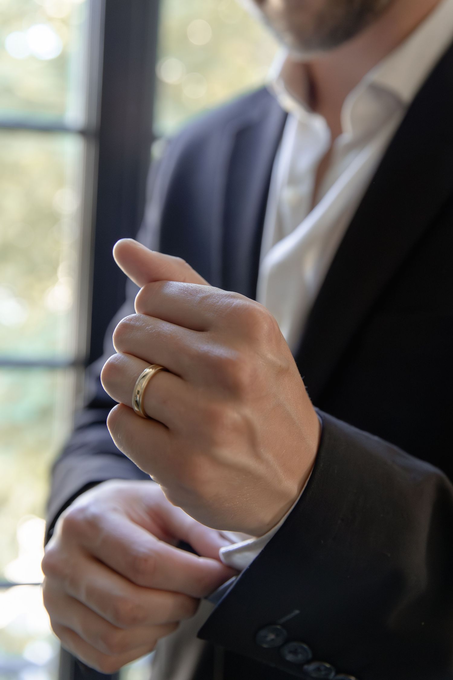 Close-up shot of hands wearing a wedding ring while gesturing during a conversation.