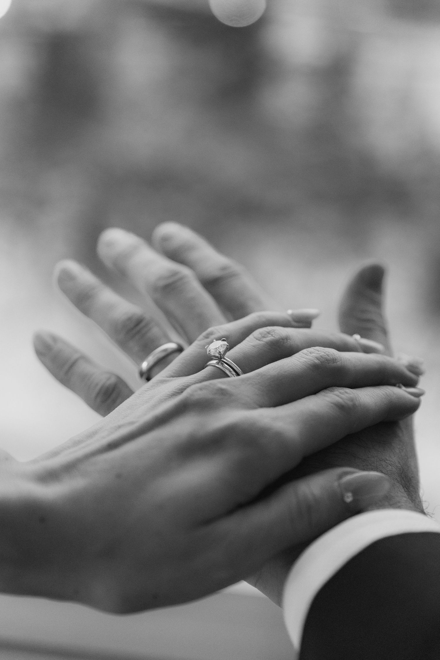 Close-up black and white photo sequence of hands exchanging wedding rings during a marriage ceremony.