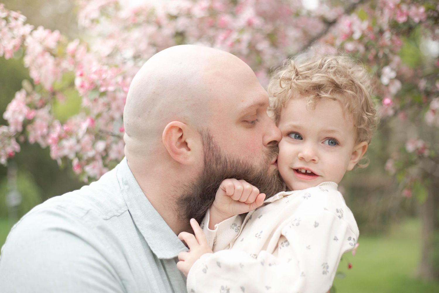 A series of tender family moments captured under blooming cherry blossom trees in springtime.