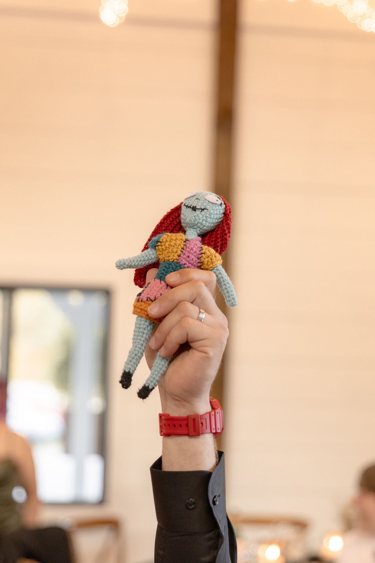 A sequence showing hands holding small colorful crocheted animal finger puppets against a warm beige background.