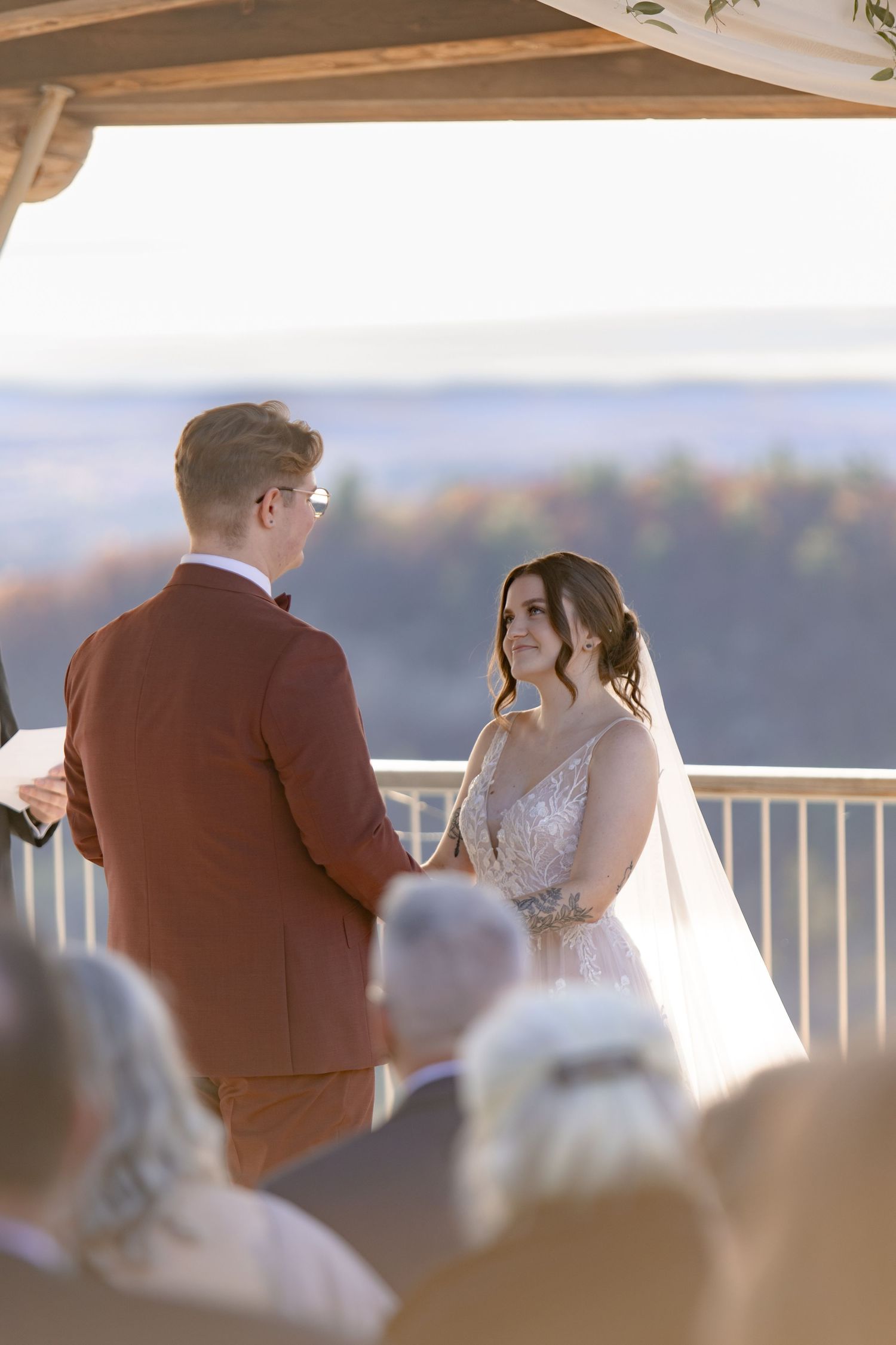 Outdoor wedding ceremony on a scenic overlook with couple exchanging vows in autumn.