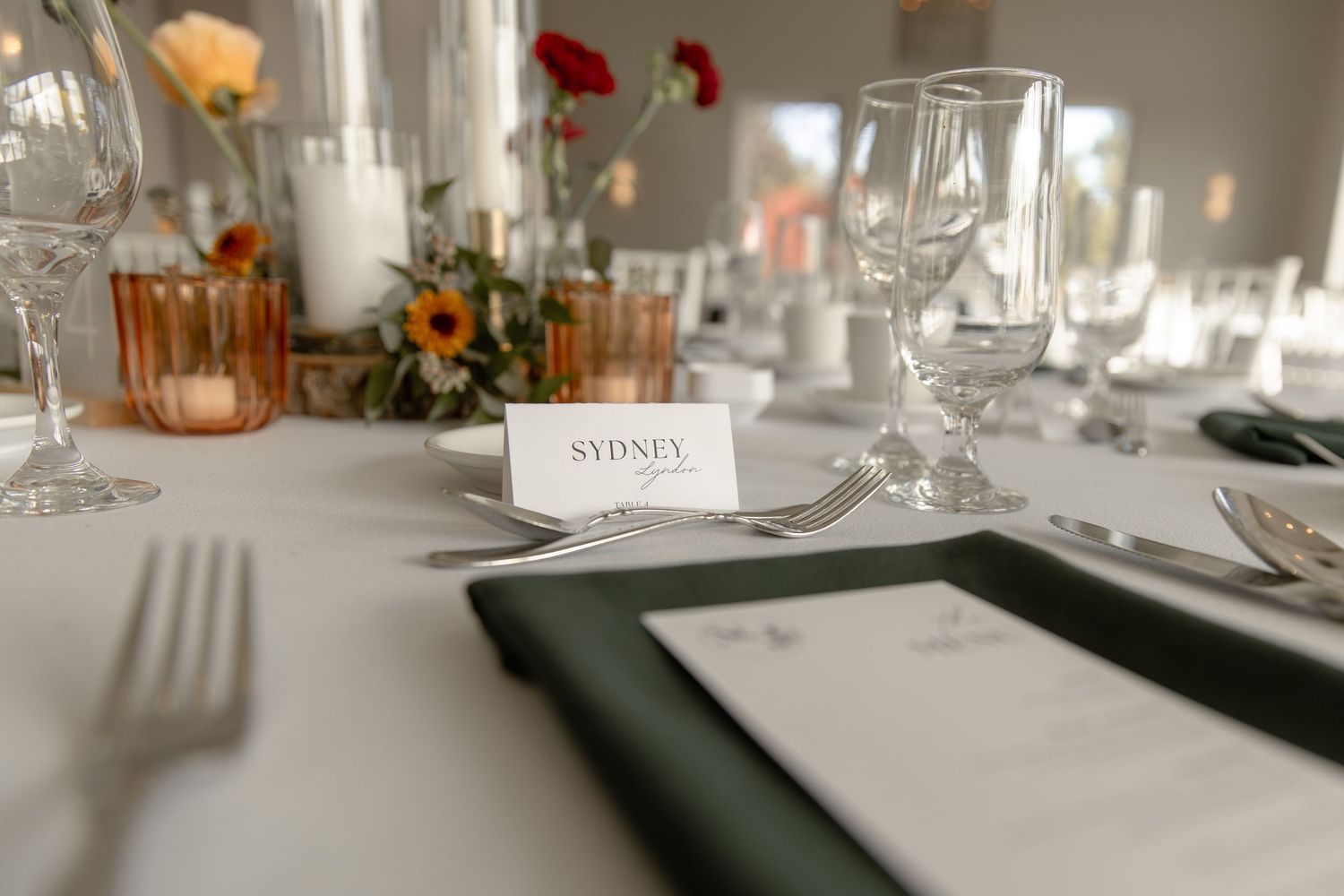 Elegant table settings with wine glasses and place cards arranged for a formal dining event.
