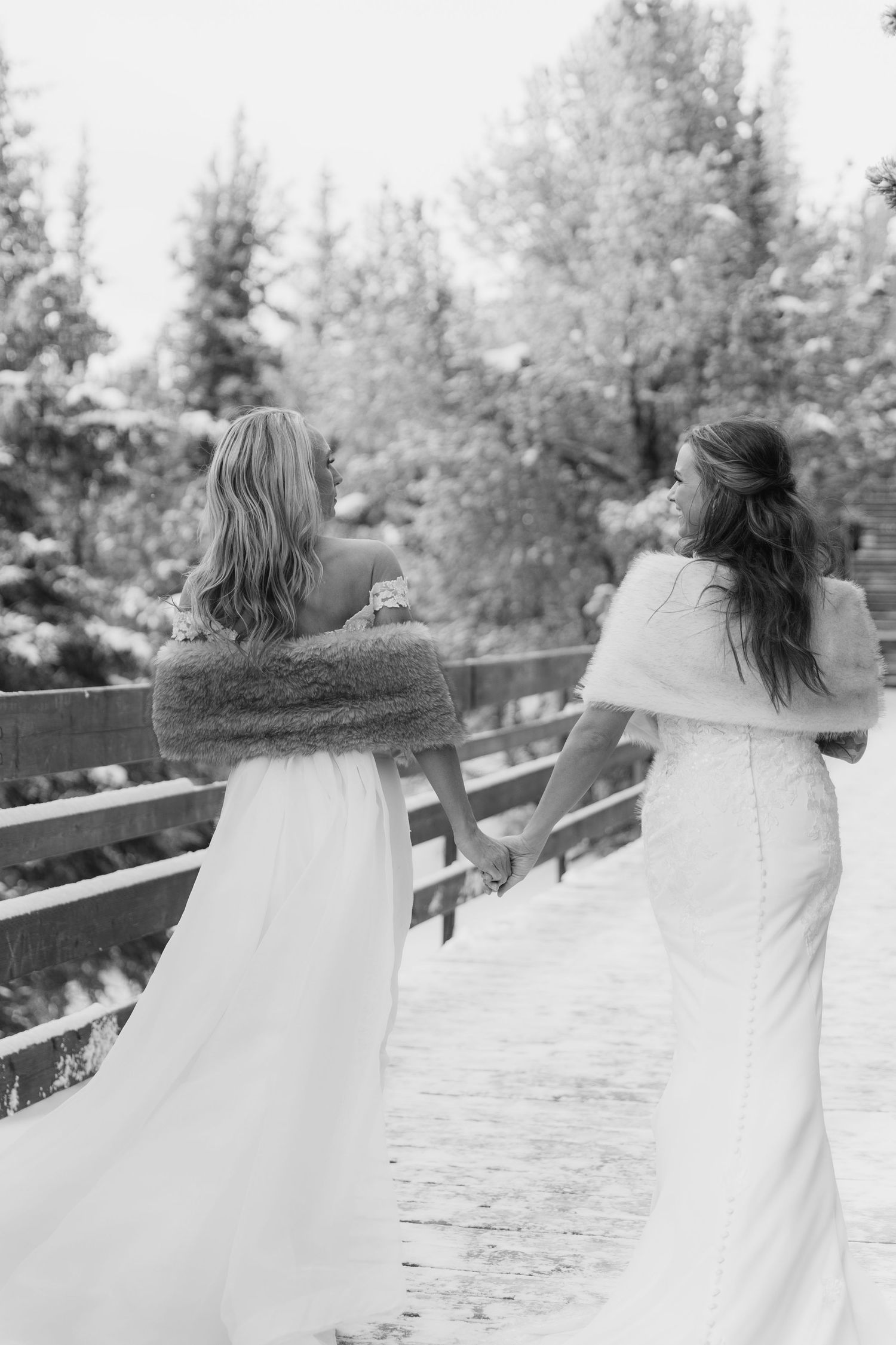 Black and white photo of two people in white dresses dancing together on an outdoor deck.