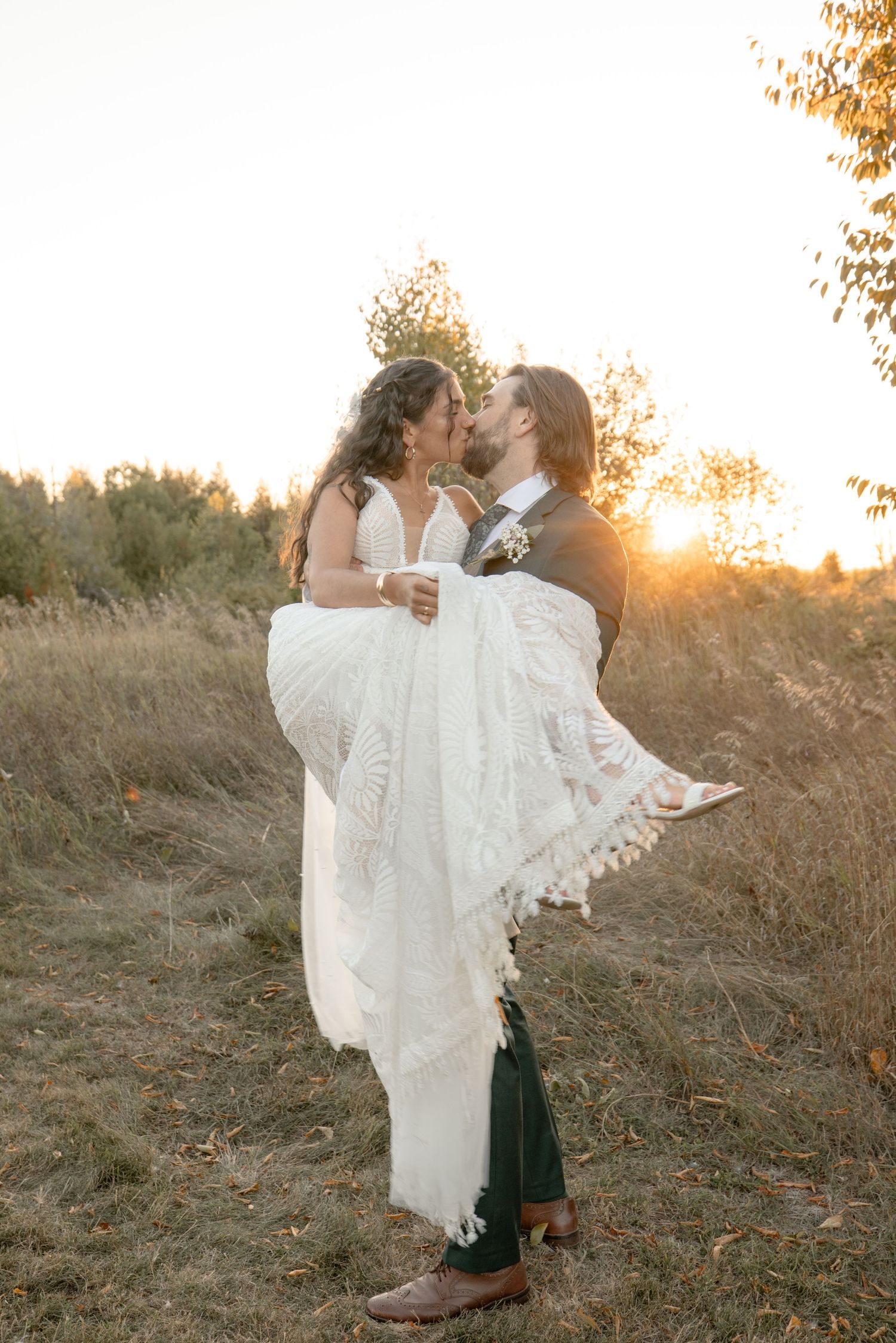 A romantic sunset wedding photo series shows a couple embracing in a grassy field during golden hour.
