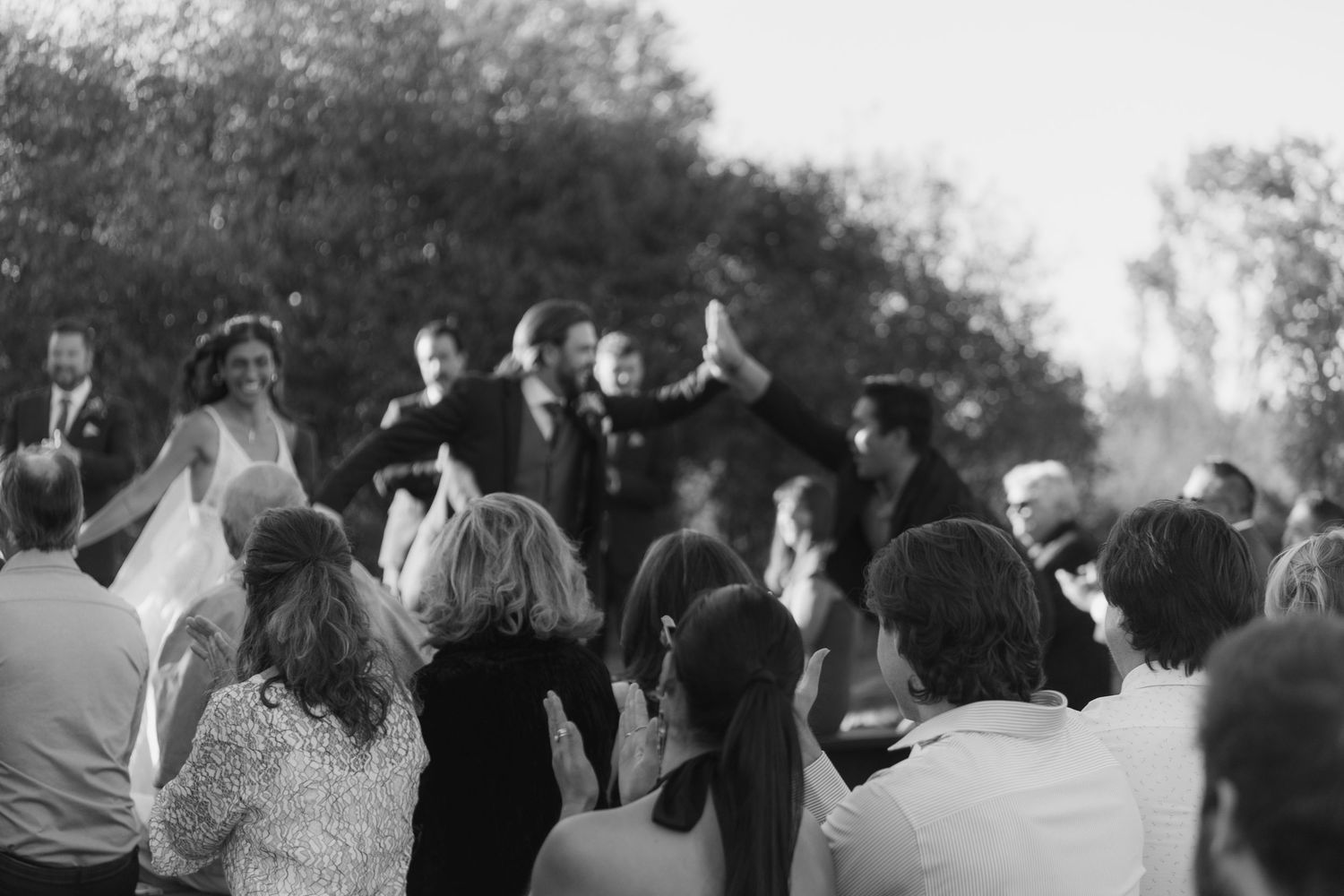 A black and white panoramic collage shows a crowd of people gathered at an outdoor event or celebration.