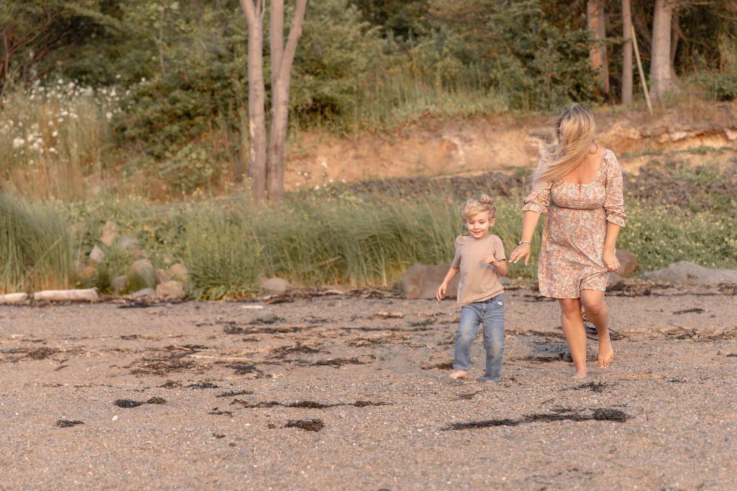 Mother and child enjoying a walk on a wooded path during a sunny afternoon.