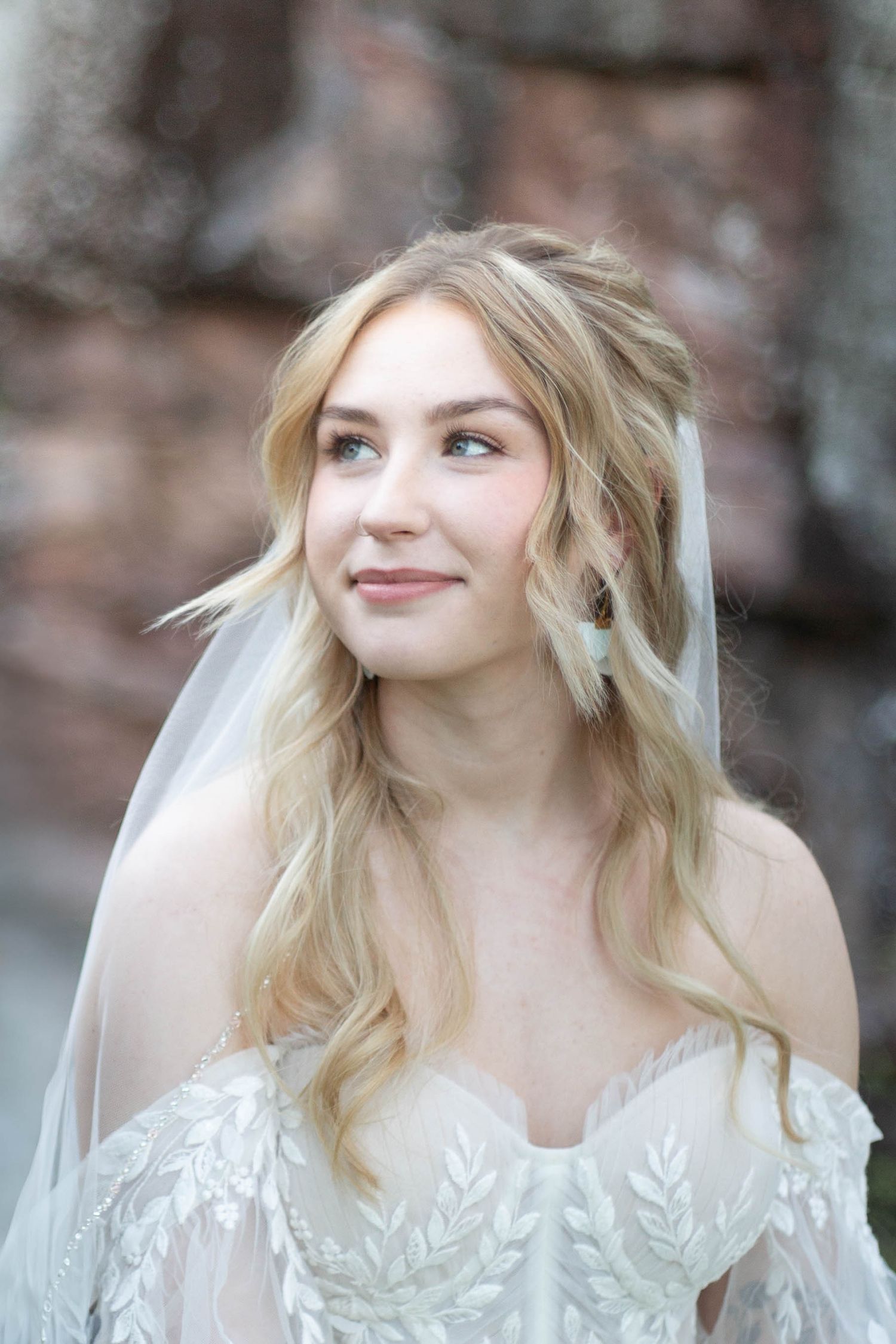 A person with wavy blonde hair wearing a white lace dress poses playfully in a series of candid portrait shots.