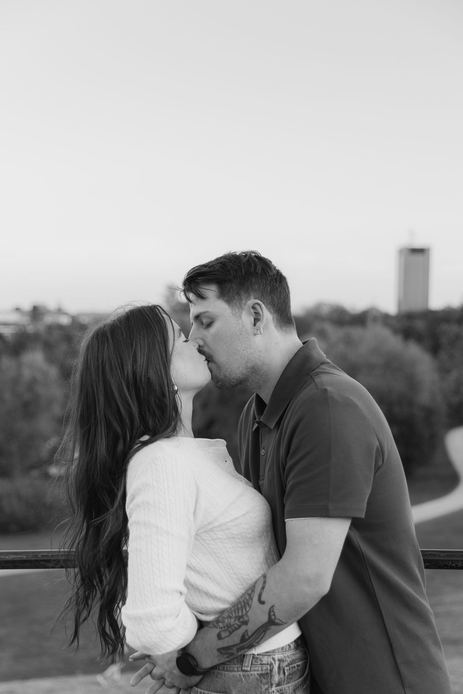 A romantic black and white photo sequence shows a couple sharing tender kisses outdoors at sunset.