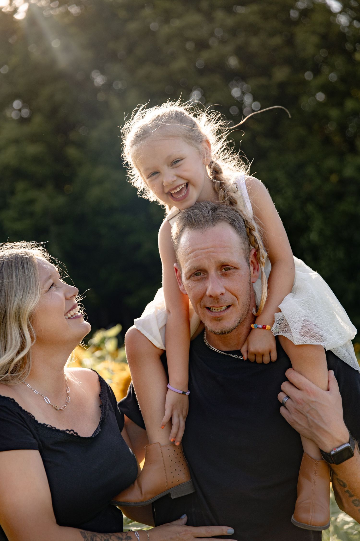 A joyful family shares candid moments together during a golden hour outdoor photoshoot.