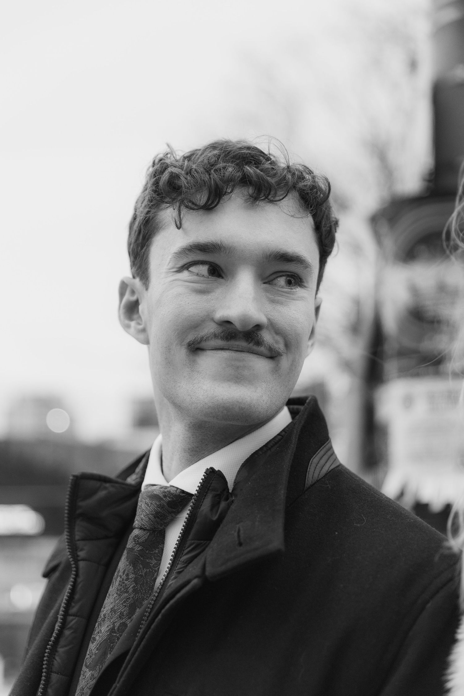 Black and white portrait series showing a person with a mustache smiling from different angles.