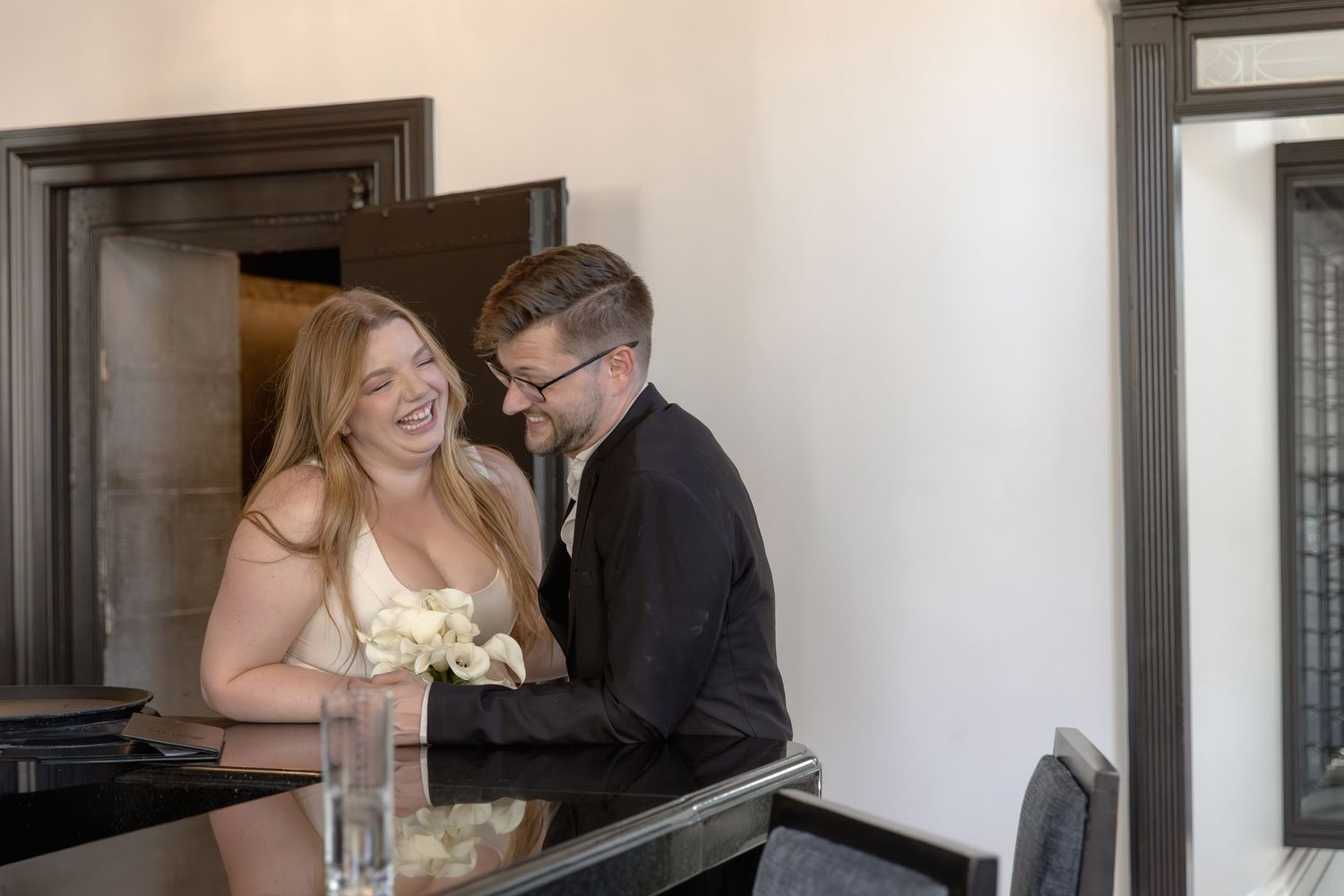A couple shares a laugh during a special moment at their elegant indoor reception.