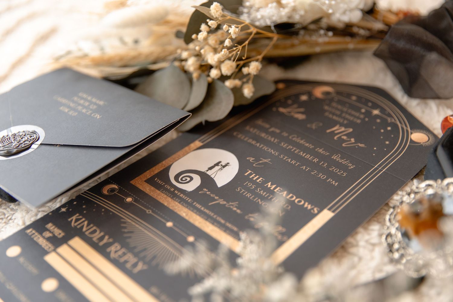 Elegant wedding invitations with gold foil details and dried flowers.